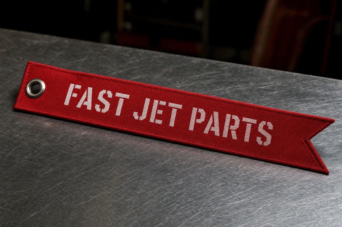 Direction C concept — remove-before-flight streamer tag on a workbench